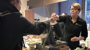 Anne Peltonen har märkt att matsvinnet minskat tydligt under de senaste tio åren. Anne Peltonen tar betalt av en lunchgäst.
