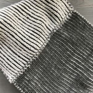 Halstub stickad i tvåfärgad patentstickning och ihopsydd med vridning. Två färgad patenstickning ihopsydd med vridning.