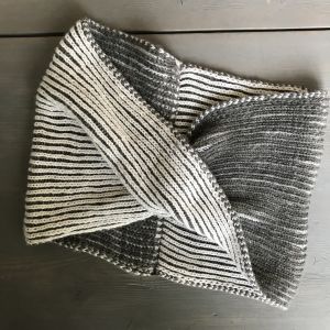 Halstub stickad i tvåfärgad patentstickning och ihopsydd med vridning. Halstub stickad i tvåfärgad patetstickning.