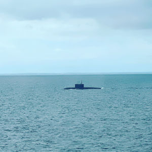 Merimaisema, jonka keskellä näkyy puoliksi upoksissa oleva sukellusvene.