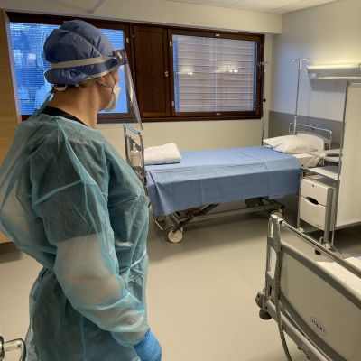 Hoitaja seisoo suojavarusteissa uuden pandemiaosaston huoneessa Seinäjoen keskussairaalassa.