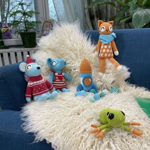 Virkade gosedjur och leksaker på en soffa.