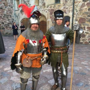 Två skådespelare står i soldatkostym från medeltiden. 