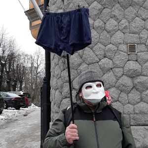 Demonstrationerna var avtrappade så att inte allt för många samlas på samma plats samtidigt. Blå kalsonger är en symbol för Navalnyj, förklarar mannen bakom masken. En man med en vit mask som täcker hela ansiktet står med en käpp som har ett par kalsonger på toppen. Mannen deltar i Navalnyj-demonstrationerna i Helsingfors.