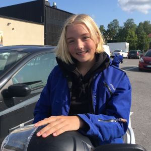 Har man moped kommer man långt. Pajula bor i Nagu men hänger ändå gärna i Pargas centrum eller åker till Åbo för att shoppa med kompisarna. Mest är hon ändå hemma med föräldrarna och rider med deras häst. maija pajula ler mot kameran. sitter på sin moped och har handen om sin mopedhjälm.