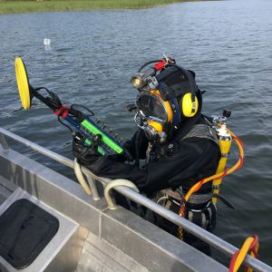 Dykare i vattnet bredvid motorbåt
