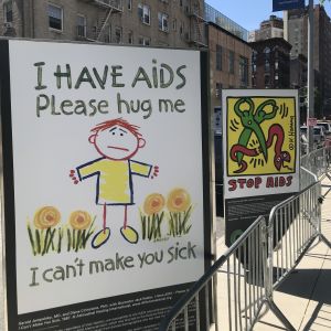Informationskampanj om aids i New York. Två reklamplakat i NYC, med texten: "Stop aids" och "I have aids, please hug me. I can´t make you sick.