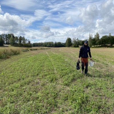 Emil Hästbacka tar jordprover från åkrar i Raseborg.
