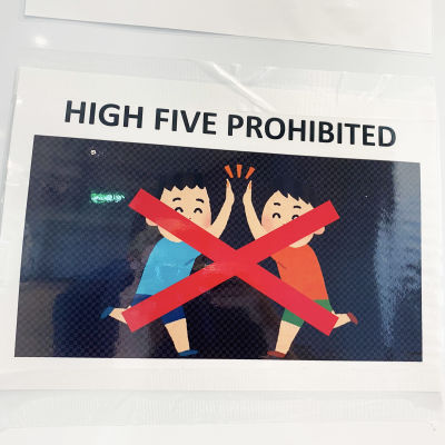 En affisch på en vägg med texten "high five prohibited".