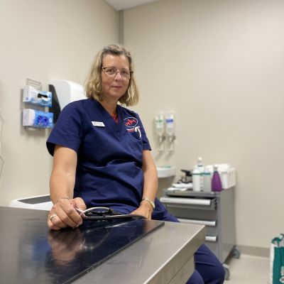 En kvinnlig veterinär sitter i sitt mottagningsrum på veterinärkliniken.