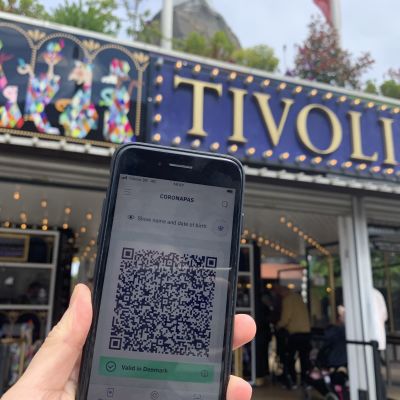Coronapass i Danmark, en telefon hålls upp framför Tivoli i Danmark