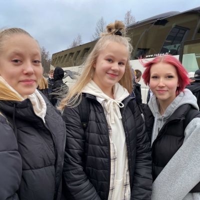 Ylöjärven yhteinäiskoulun oppilaat Unna Aalto, Aliisa Mäkinen ja Salla Laakkonen tilausbussin edessä lähdössä taidetestaajien matkalle.