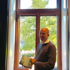 Samu Nyström står vid ett fönster som vetter mot Esplanadparken. Samu Nyström står vid ett fönster som vetter mot Esplanadparken.