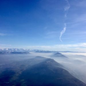 De franska och schweiziska Alperna täcks delvis av moln och atmosfären ovanför ser kylig ut i solskenet.