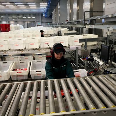 Atrian logistiikkakeskuksessa lajitellaan ruokapaketteja kuljetuslaatikoihin.