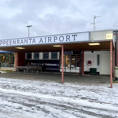 Lappeenrannan lentoaseman sisäänkäynti ulkoa kuvattuna. Oven yläpuolella lukee: Lappeenranta airport.