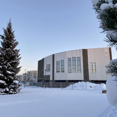 Rovaniemen kaupungintalo lumisessa maisemassa, vasemmalla puolella iso joulukuusi