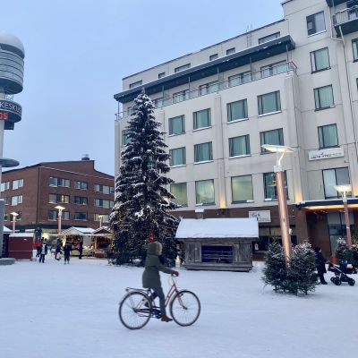 Rovaniemen Lordinaukio, maassa lunta, ihminen ajaa polkupyörällä.