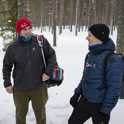 Jonas Roslund, Lari Biskop ja Henri Hämäläinen lumisessa metsässä frisbeegolfreput selässään.