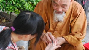 Tron på feng shui och astrologi är stark. Många låter också regelbundet spå sig. En man spår i en flickas hand.