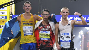 Medaljtrion Karlström, Yamanashi och Mizinov. Perseus Karlström,Toshikazu Yamanishi och Vasiliy Mizinov står på rad efter målgång.