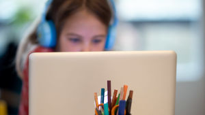 Än så länge är det väldigt få personer som rör sig i Vasa övningsskola varje dag, eftersom den stora majoriteten av elever är hemma och får distansundervisning. Skolelev deltar med fokuserad blick på datorskärm i distansundersvisning.