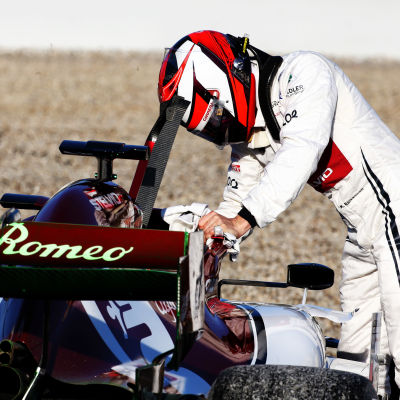 Kimi Räikkönen lutar mot sin bil.