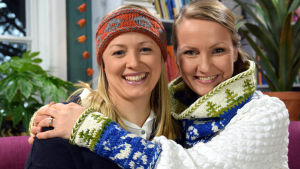 Elin Skagersten-Ström ja Lee Esselström ja neulotut Suomi 100 -asusteet.