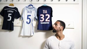 Rio Ferdinand on entinen huippujalkapalloilija ja kolmen lapsen yksinhuoltajaisä. Rio Ferdinand seisoo ja katsoo naulakkoon ripustettuja lasten pelipaitoja.