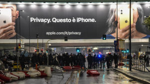 För många småföretagare kan de nya restriktionerna bli ödesdigra Kravallpolis står framför en stor iphone-reklamskylt