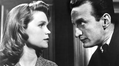 Nainen (Lee Remick) ja mies (George C. Scott) tuijottavat toisiaan tiiviisti oikeussalissa. Kuva elokuvasta Erään murhan anatomia
