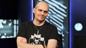 Lasse Grönroos i studion Lasse Grönroos i Yle Fem-programmet Tredje Statsmakten, i studion med händerna i kors.