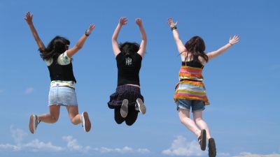 tre flickor hoppar upp i luften