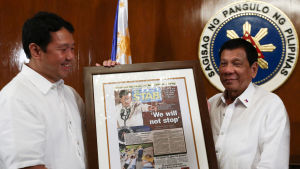 President Rodrigo Duterte (th) emottar en dagstidnings förstasida där det står, Vi kommer inte att stoppa - en hänvisning till den omstridda kampanjen Skjut för att döda President Rodrigo Duterte (tv) emottar en dagstidnings förstasida där det står, Vi kommer inte att stoppa - en hänvvisning till Duertes omstridda kampanj Skjut för att döda