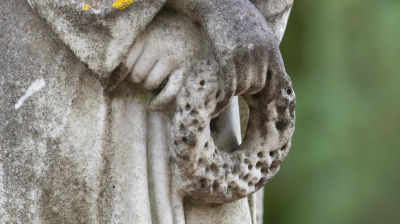 En närbild på händerna i en gravstaty. 