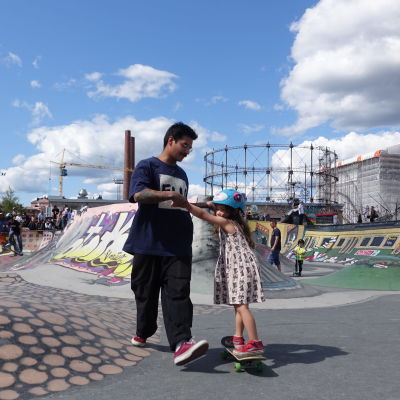 Pappa som drar sin fem-åriga dotter på en skejtboard i Söderviks skejtpark