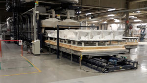 Den moderniserade tunnelugnen vid fabriken i Ekenäs sparar mycket energi, uppger Geberit. Ett antal wc-stolar uppradade framför en lång förbränningsugn på en fabrik.