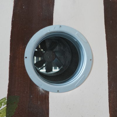 Ett ventilationsrör med en fläkt i en vägg.