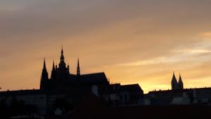 Solen går ner över Prag och min ungdom, minnena blir suddigare. Kyrkosiluett mot solnedgång - Prag