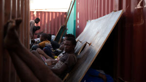Flyktingar som har räddats ur Medelhavet väntar på att transporteras till ett interneringsläger i Tripoli. Flyktingar väntar på att transporteras till ett libyskt interneringsläger