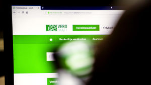 Behöver du komma åt ditt skattekort vid årsskiftet? Eller kanske räkna ut din skatteprocent? Då gäller det att göra det i tid. Det blir ett dataavbrott under några dagar kring nyår. En person sitter framför en dator där man ser hemsidan vero.fi, alltså Skatteförvaltningens webbsida.