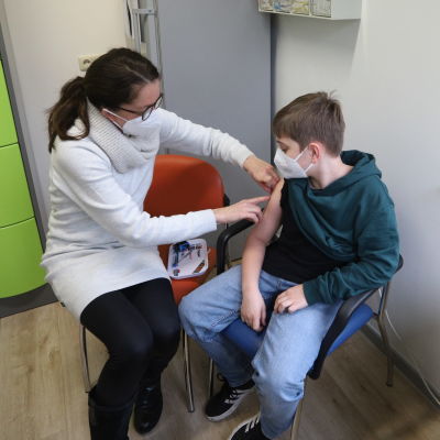 En pojke har nyss fått vaccinet och får nu ett plåster på armen.