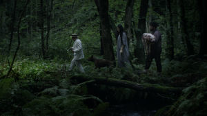 Glada vi i skogen gå, glatt vi le och sjunga. Peter Belli, Brandy Litmanen och Morad Baloo Khatchadorian ute på vandring. Tre gestalter rör sig genom en mörk skog i filmen Kooko-di Koko-da.