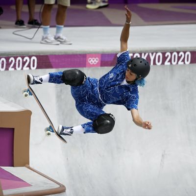 Skateboardare i blå dräkt under sitt åk.