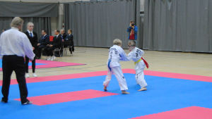 Två av de yngre deltagarna går en match i taekwondo. Två unga idrottare går en match i taekwondo.