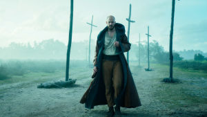 Tv-serien "Cursed" baserar sig på en bok med samma namn skriven av serieskaparna Frank Miller och Tom Wheeler. Gustaf Skarsgård spelar rollen som trollkarlen Merlin. Svenska skådespelaren Gustaf Skarsgård spelar trollkarlen Merlin i tv-serien Merlin. Här ser man honom gå i ett disigt mörkt landskap där flera träkors syns.