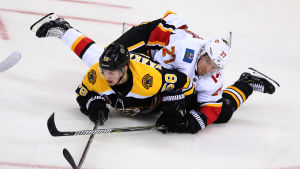 Calgarys Auston Czarnik lägger sig på Urho Vaakanainen. Calgarys Auston Czarnik lägger sig på Urho Vaakanainen.
