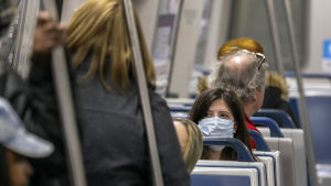 Till exempel i kollektivtrafiken rekommenderas användningen av munskydd. En kvinna bär munskydd på ett metrotåg i Atlanta, USA.