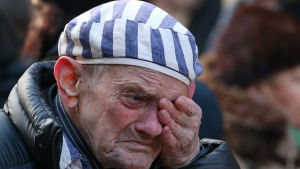 En man sörjer under minnesceremonin i Auschwitz, 75 år efter att lägret intogs av den Röda armén. En man sörjer under en ceremoni i Auschwitz som ordnades 75 år efter att lägret befriades.