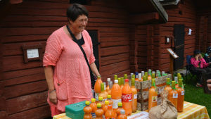 Benita Nordgren tycker det är god stämning och en idealisk omgivning på marknaden. Benita Nordgren säljer färskpressad havtornssaft på Brages skördemarknad.